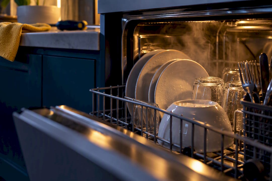 Warm dishes steaming inside a dishwasher